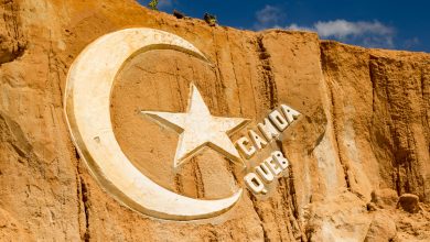 Canoa Quebrada - weißes Logo auf roter Klippe