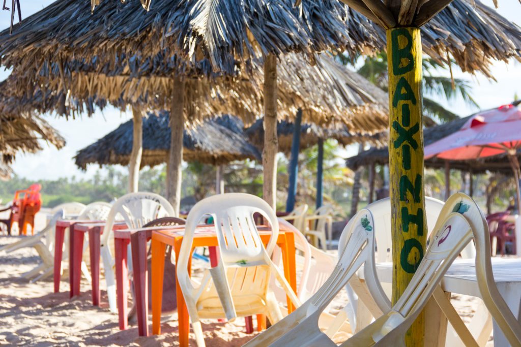 Plastikstühle am Strand von Imbassaí